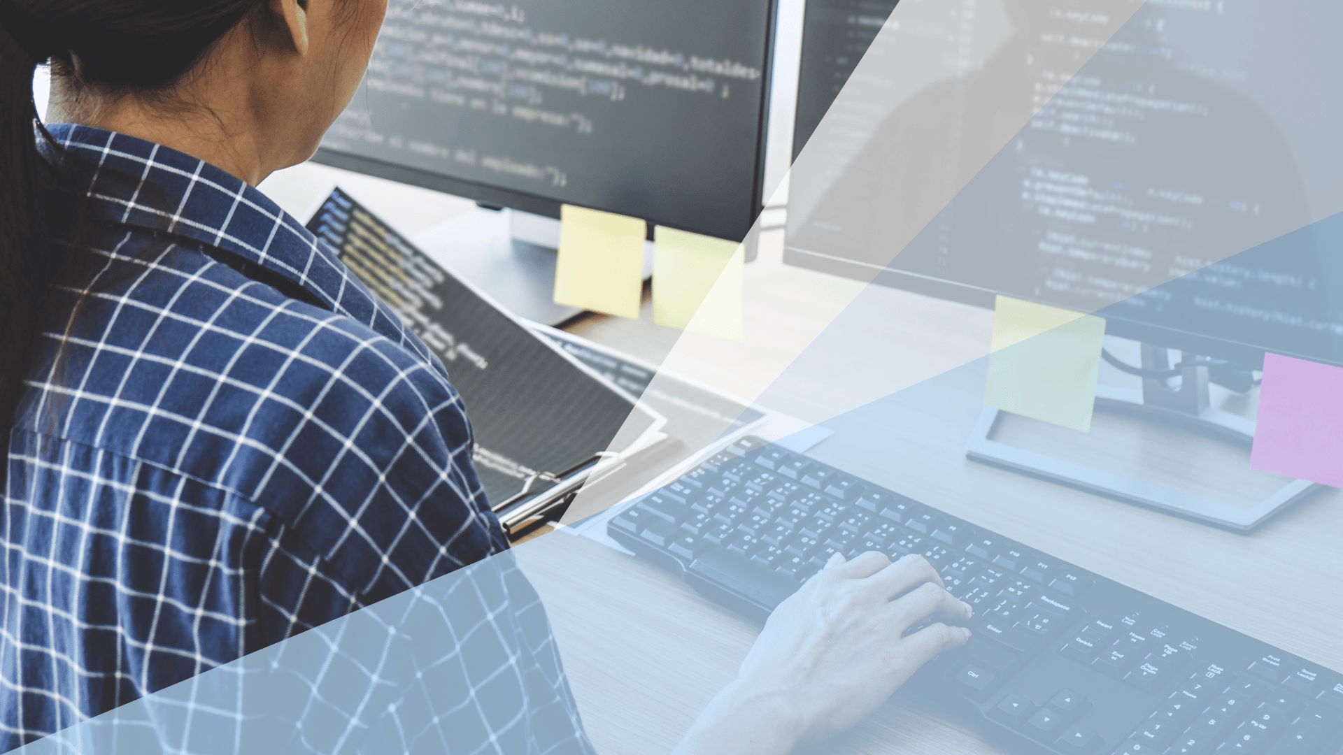 Close-up of person typing on computer with blue and white transparent shapes overlayed on top of image