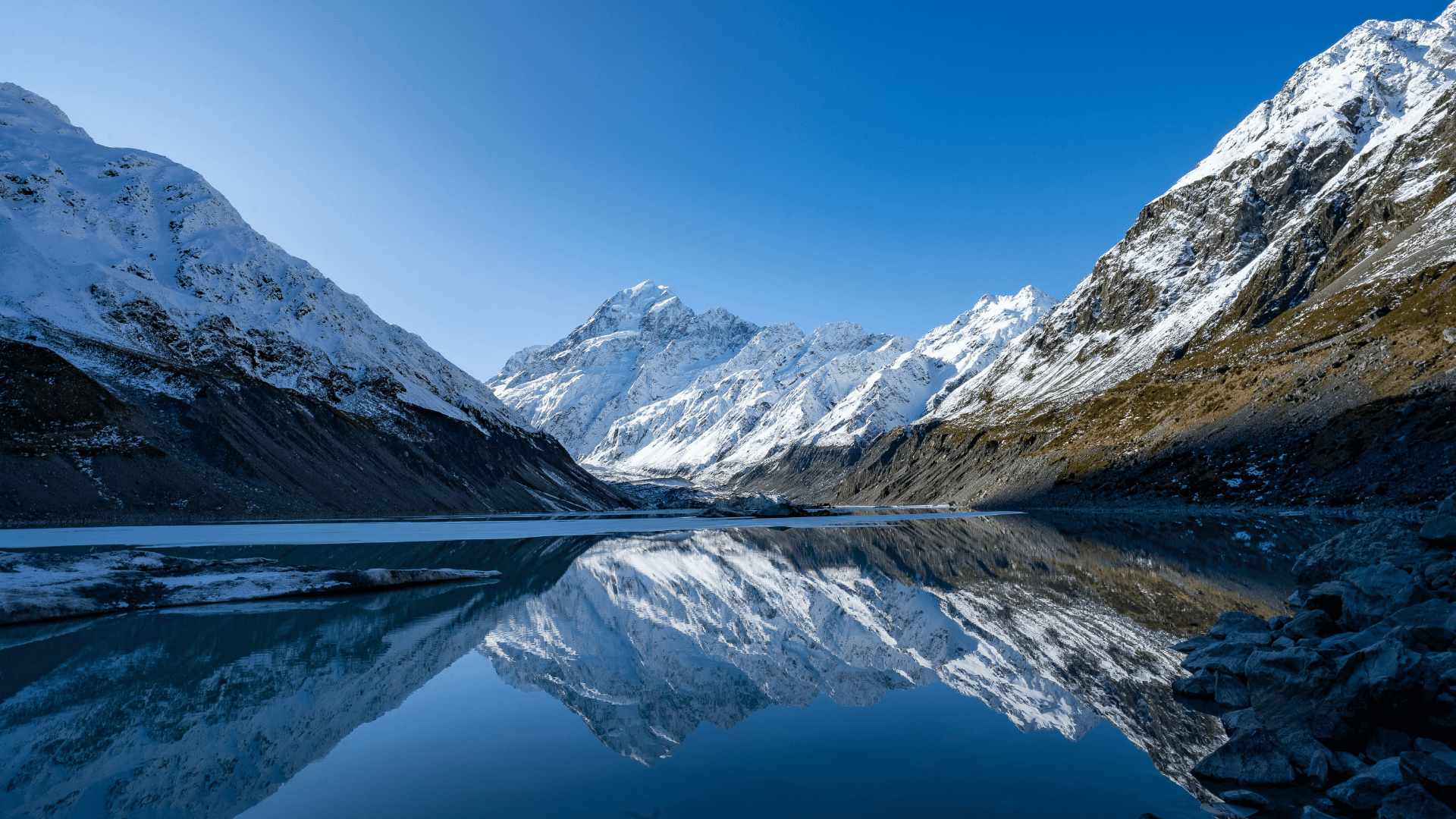 Snowcapped mountains reflected in clear lake