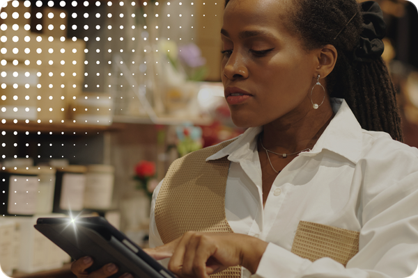 Woman using a tablet with decorative dots in top left corner
