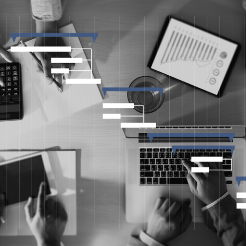 Black and white image of hands and computers working with white and blue lines and bars in forefront
